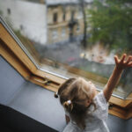 Właściwości izolacyjne okien. Dziewczynka za oknem.